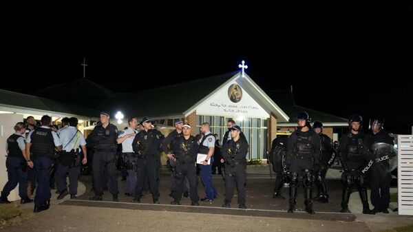 Сотрудники службы безопасности возле ассирийской церкви в Сиднее, где произошло нападение на священника. 15 апреля 2024