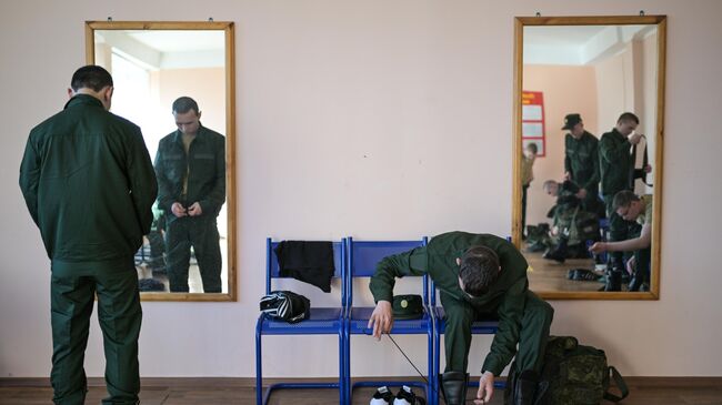 Призывники переодеваются в военную форму перед отправкой на военную службу