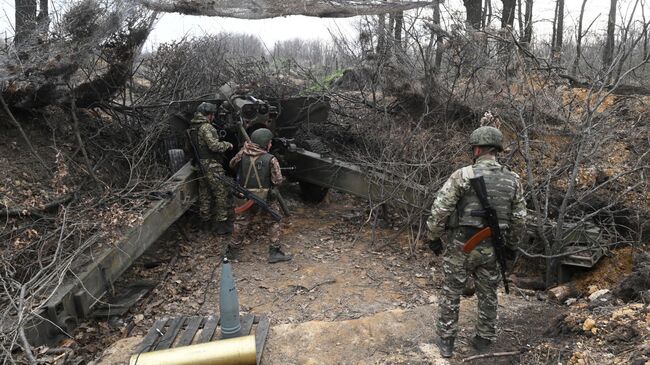 Военнослужащие ведут стрельбу из артиллерийского орудия