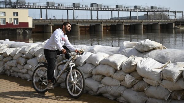 Местный житель у мешков с песком для защиты от паводка на берегу реки Тобол в Кургане