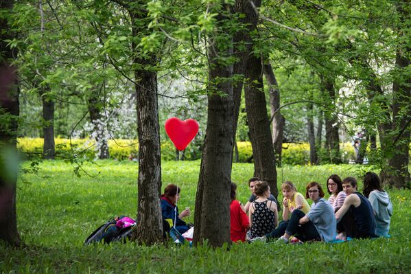 Горожане отдыхают в яблоневом саду в московском музее-заповеднике Коломенское