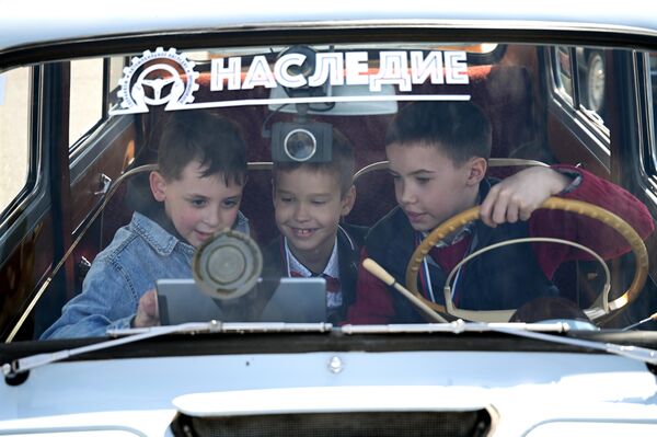 Посетители в салоне автомобиля перед стартом ретроралли Столица в Москве. Ралли откроет 9-й сезон Кубка Российской автомобильной федерации по ралли на классических автомобилях