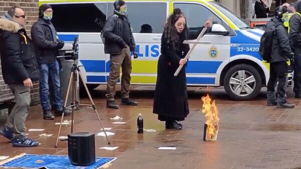 Жительница Швеции Джейд Сандберг сжигает Священный Коран в Стокгольме. Кадр видео