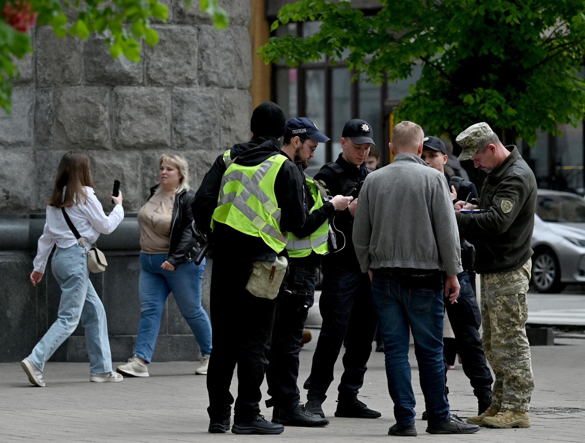 Украинские военнослужащие и полицейские проверяют документы мужчины в центре Киева - РИА Новости, 1920, 15.05.2024