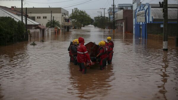 Спасатели на затопленной улице города Сан-Себастьян-ду-Каи. 2 мая 2024