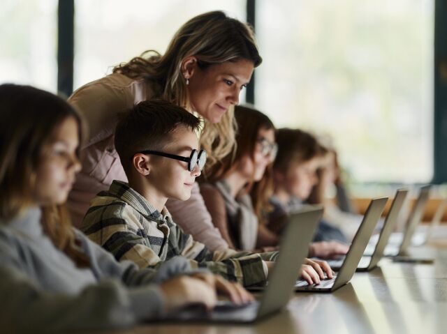 Школьники занимаются за компьютерами во время урока