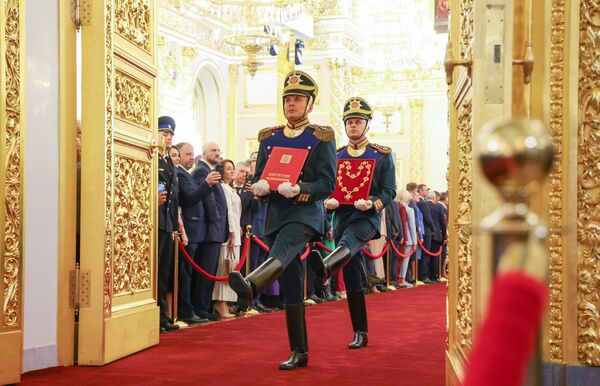 Солдаты Президентского полка вносят специальный экземпляр Конституции и знак президента на церемонию инаугурации президента РФ Владимира Путина в Кремле