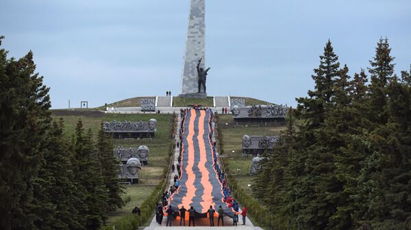 Участники акции, приуроченной к празднованию Дня Победы, развернули Георгиевскую ленту длиной 300 метров на мемориальном комплексе Саур-Могила в Донецкой Народной Республике