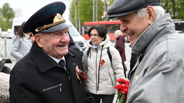 Участники акции Парад у дома ветерана дарят цветы ветерану ВОВ Алексею Николаевичу Коблеву на Советской площади в Казани