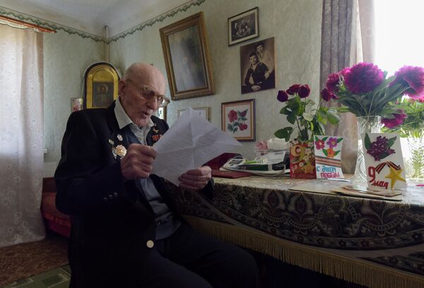 Ветеран Великой Отечественной войны Николай Иванович Денисенко читает письмо от волонтера в своем доме в Кировском районе Донецка