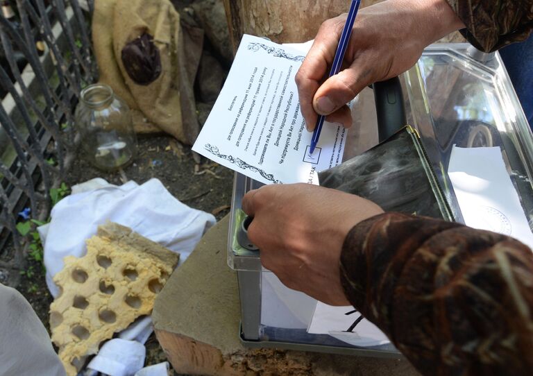 Боец народного ополчения участвует в голосовании на референдуме о статусе самопровозглашенной Донецкой народной республики на блокпосту в Славянске