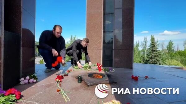 Жители Донецка возлагают цветы у памятника Жертвам фашизма. Кадр видео