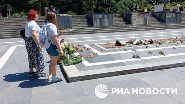 Жители Тбилиси несут цветы к Могиле Неизвестного Солдата. Кадр видео