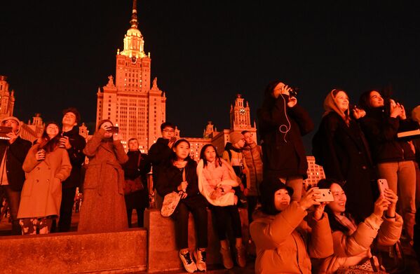 Люди смотрят световое шоу на фасаде главного здания МГУ на Воробьевых горах в Москве в честь празднования 79-й годовщины Победы в Великой Отечественной войне