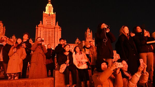 Люди смотрят световое шоу на фасаде главного здания МГУ на Воробьевых горах в Москве в честь празднования 79-й годовщины Победы в Великой Отечественной войне
