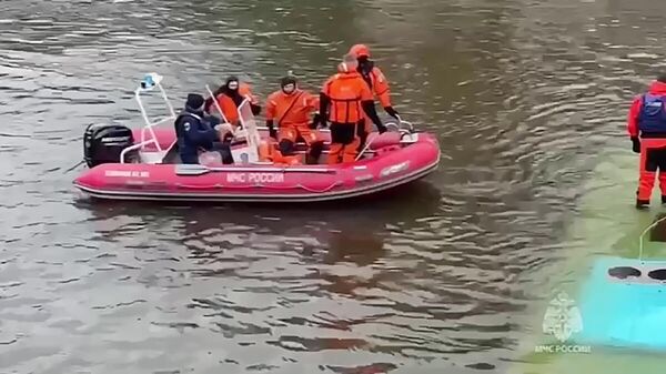Сотрудники спасательной службы МЧС РФ работают на месте падения пассажирского автобуса с Поцелуева моста в реку Мойку
