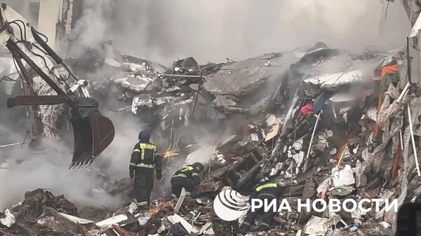 Разбор завалов на месте частичного обрушения дома после атаки ВСУ в Белгороде