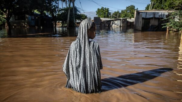 Девушка во время наводнения в Гариссе, Кения
