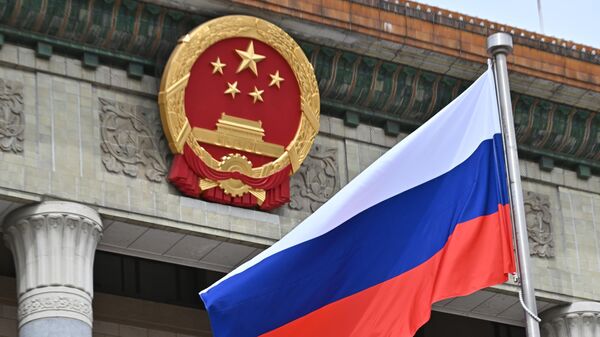 Российский флаг перед церемонией официальной встречи президента России Владимира Путина и председателя КНР Си Цзиньпина в Пекине