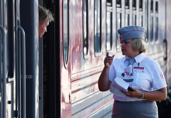 Проводница на перроне возле туристического поезда Белорусский вояж на Белорусском вокзале в Москве Проводница на перроне возле туристического поезда Белорусский вояж на Белорусском вокзале в Москве