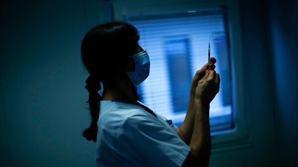 Медсестра готовит шприц с вакциной Pfizer/Biontech против COVID-19 в больнице MontLegia CHC в Льеже