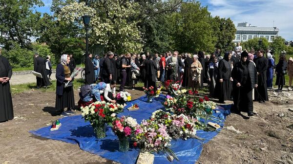 Прихожане УПЦ несут цветы и молятся на месте разрушенной Владимиро-Ольгинской часовни Десятинного мужского монастыря 