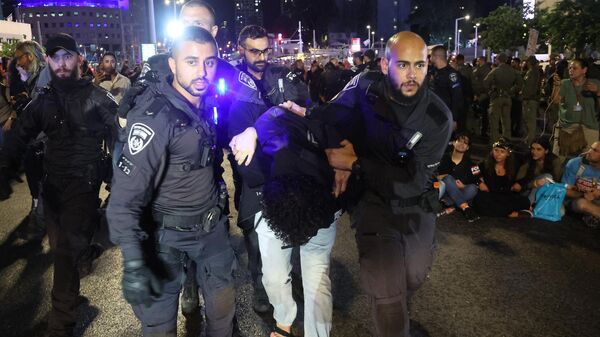 Израильская полиция задерживает протестующего во время антиправительственного митинга в Тель-Авиве. 18 мая 2024