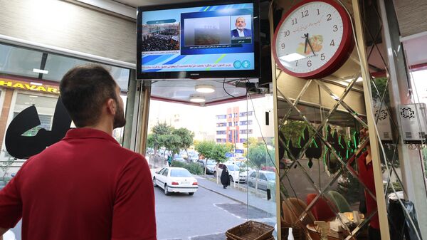 Иранец смотрит новости по телевизору в ресторане Тегерана о крушении вертолета президента Ирана в провинции Восточный Азербайджан