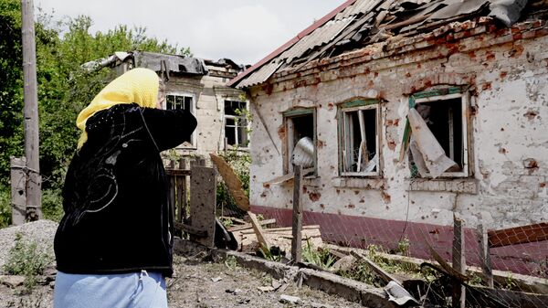Пенсионерка плачет у разбитого дома своих погибших родственников
