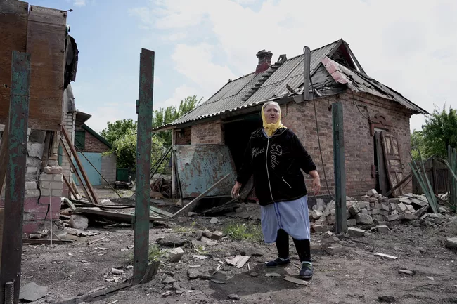 Пенсионерка у разбитого дома