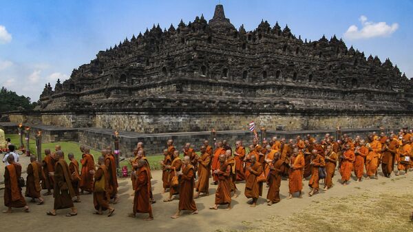 Буддийские монахи на фоне храма Боробудур во время шествия в честь Дня Весак в Магеланге