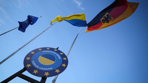 Логотип Миссии военной помощи Европейского Союза в поддержку Украины рядом с флагами ЕС, Украины и Германии на военном полигоне Клиц