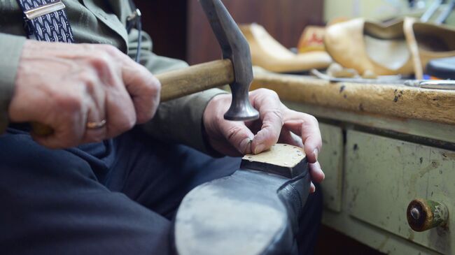 Мастер по ремонту и пошиву обуви за работой