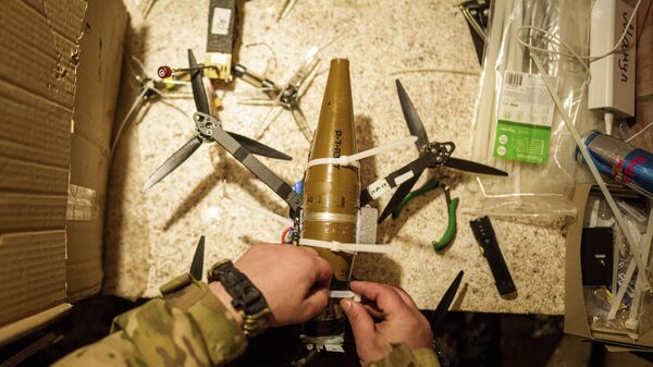 Украинский военнослужащий закрепляет боеприпас на дрон