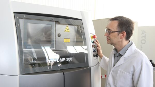Профессор кафедры материаловедения и нанотехнологий БелГУ Сергей Жеребцов наблюдает за процессом изготовления изделия на 3d-принтере