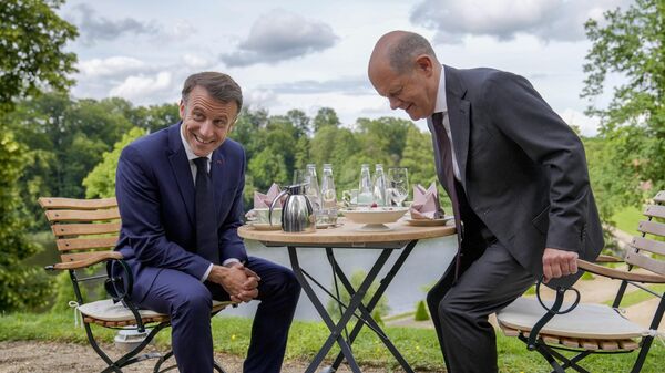Президент Франции Эммануэль Макрон и канцлер ФРГ Олаф Шольц во время встречи в саду гостевого дома правительства Германии в Мезеберге. 28 мая 2024