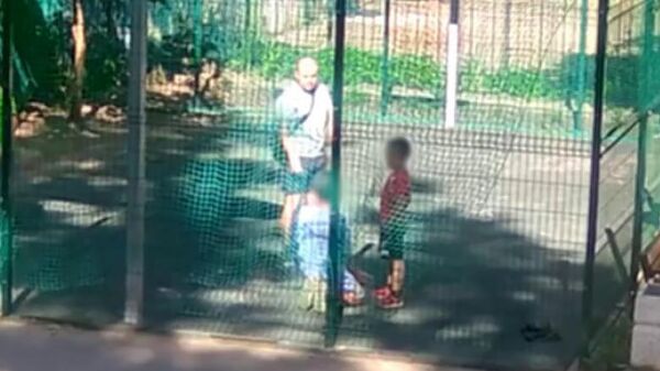 Кадр видео с мужчиной, заставившем ребенка встать на колени на детской площадке в Воронеже