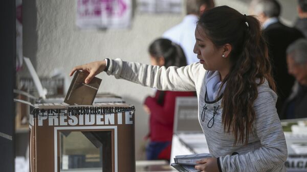 Девушка голосует во время всеобщих выборов в Мехико