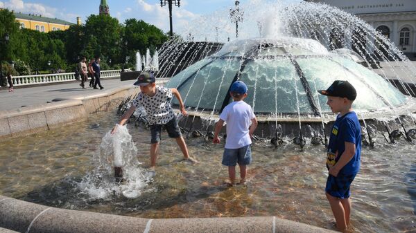 Дети купаются в фонтане на Манежной площади в Москве в жаркую погоду