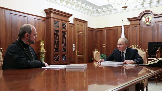 Президент РФ Владимир Путин и руководитель фонда Круг добра протоиерей Александр Ткаченко во время встречи в Международный день защиты детей