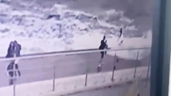 Кадр видео, на котором волна сбивает девушку с ног на набережной в Одессе