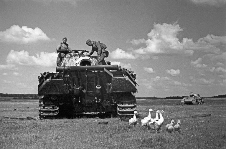 Бойцы 3-го Белорусского фронта у сожженного немецкого танка Pz.Kpfw. V Пантера на поле боя.