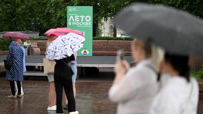 Люди во время дождя в Москве