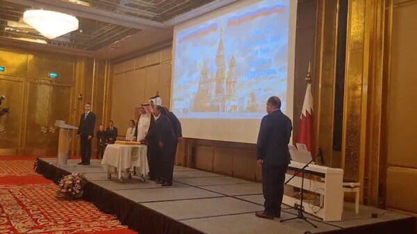 Почётные гости празднования Дня России в Катаре разрезают праздничный торт саблей. 12 июня 2024