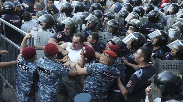 Полиция преграждает путь протестующим во время митинга против премьер-министра Никола Пашиняна в Ереване, Армения. 12 июня 2024