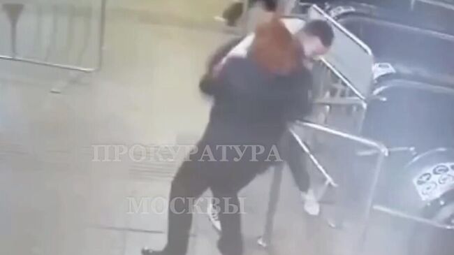 Кадр видео, на котором видно, как мужчина нападает на контролера Московского метрополитена