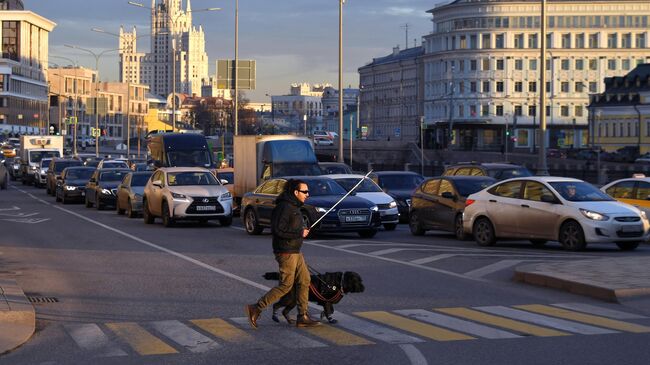 Мужчина переходит дорогу на одной из улиц Москвы