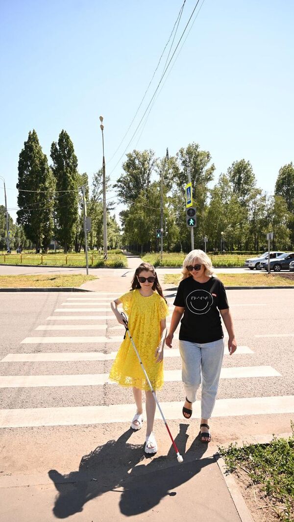 Тифлопедагог Марта Любимова с учеником на обучающей прогулке