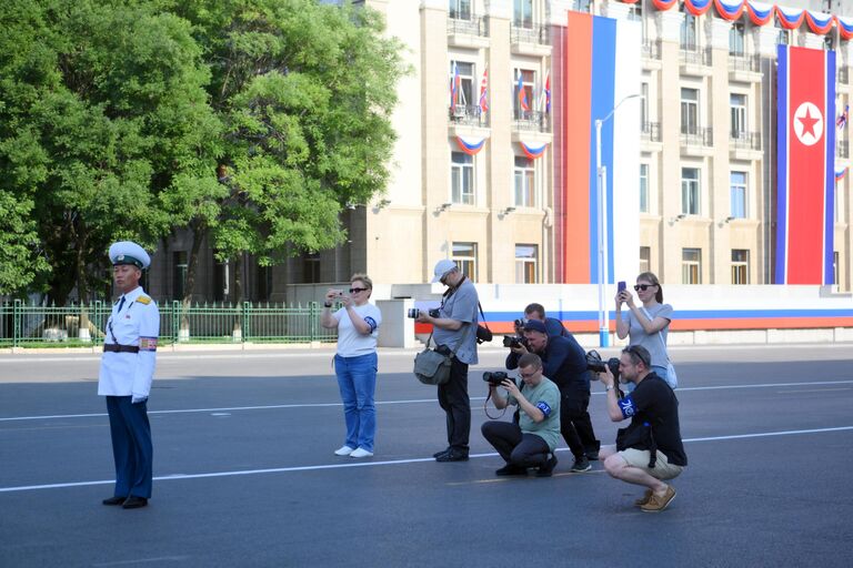 Журналисты занимаются фотосъемкой на улице в Пхеньяне перед визитом президента РФ Владимира Путина