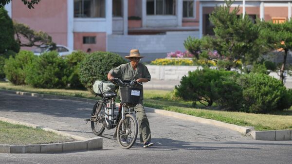 Житель с велосипедом на улице в Пхеньяне